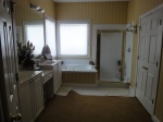 Master bathroom before picture, white cabinets and white tile.