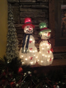 Lit snowmen, trees and mantle garland