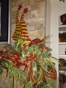"Grinch" trees frame the sides of the tv on this whimsical mantle.