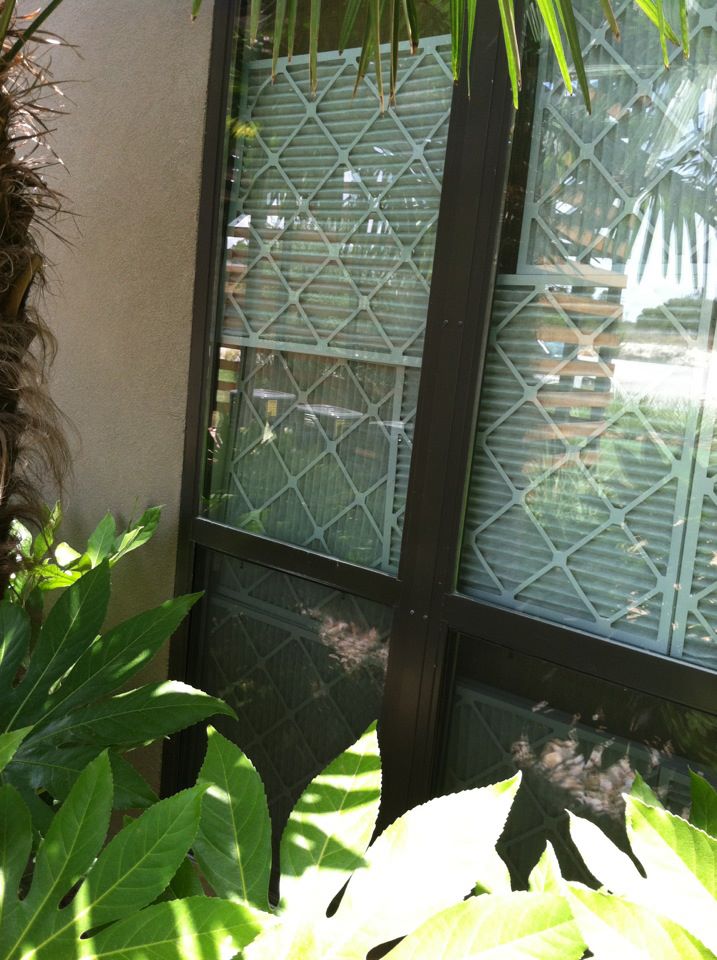 Air conditioning filters are placed in a grid on the inside of windows to keep out the sun.